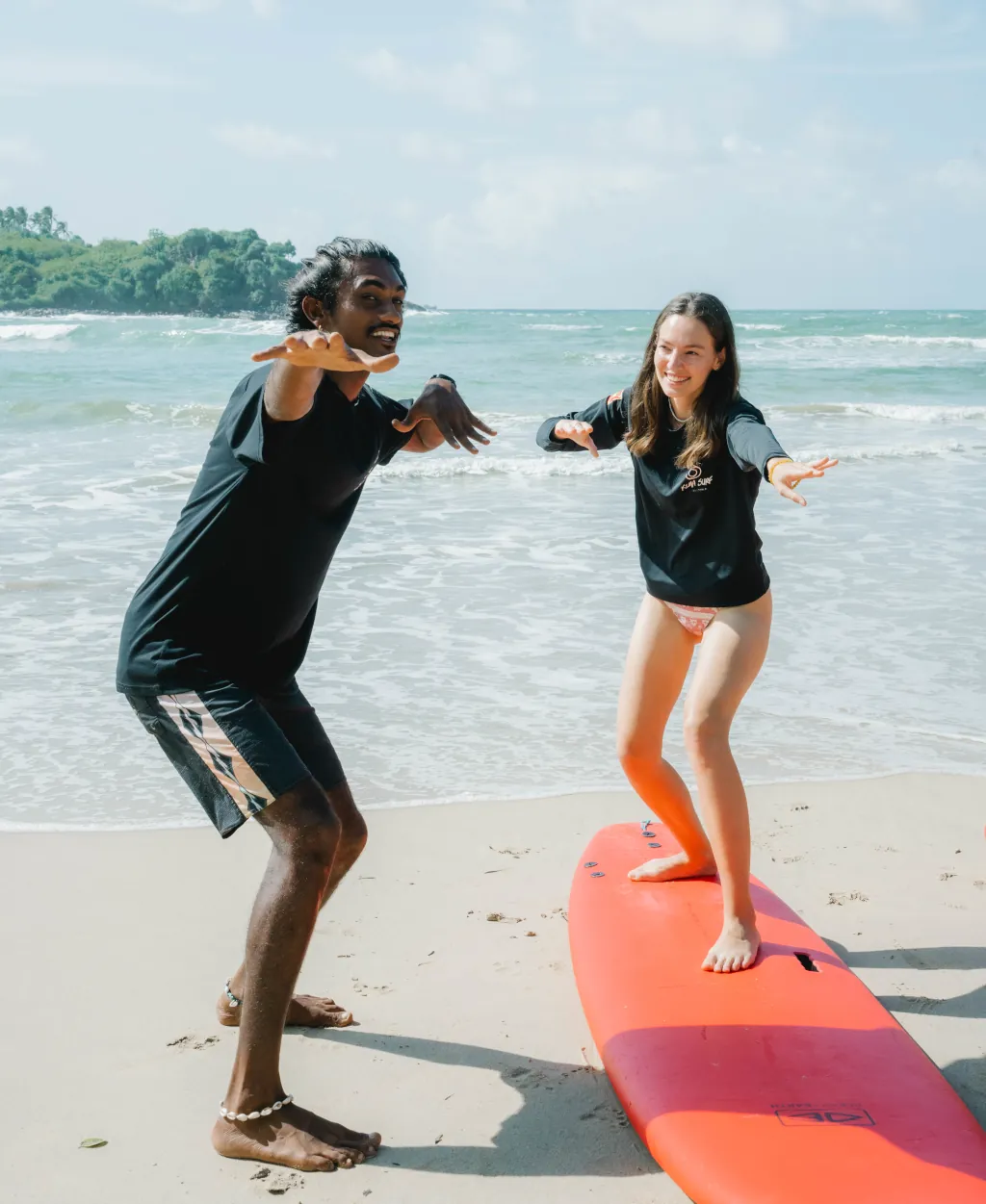 A local surf guide who is teaching a beginner surfer in Sri Lanka