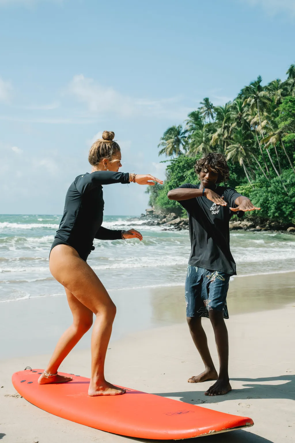A surf guide teaching a beginner surfer in Sri lanka
