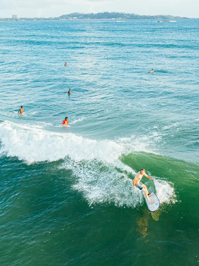 Kima surf guest with surf guides in an empty line up