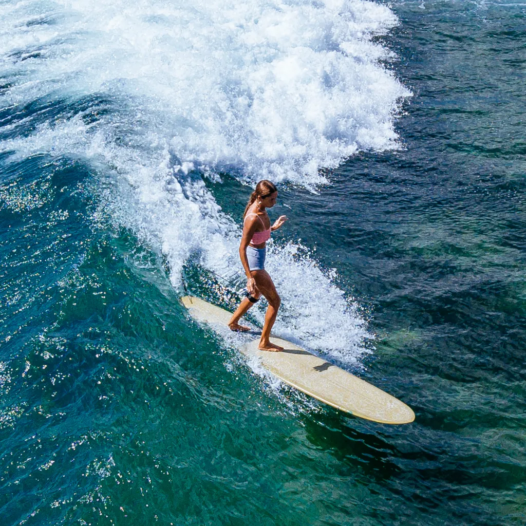 a girl riding her longboard on Sri Lanka's waves
