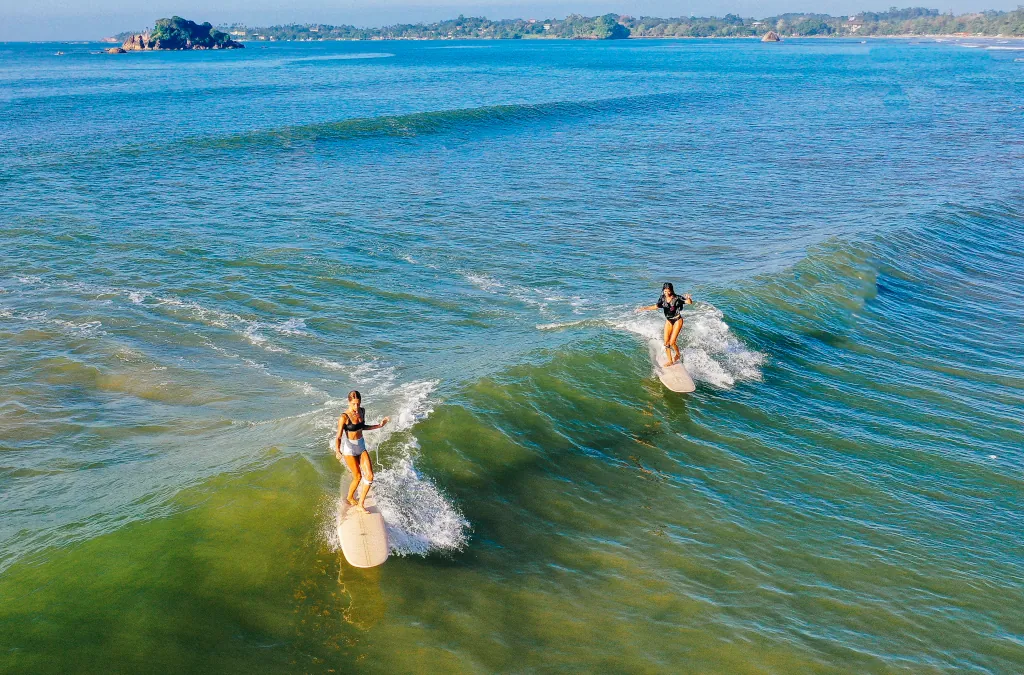 Two longboarders in the Indian ocean, working on their cross-stepping