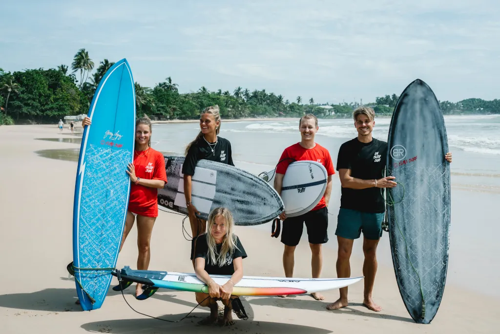 group of happy surfers at the beach
