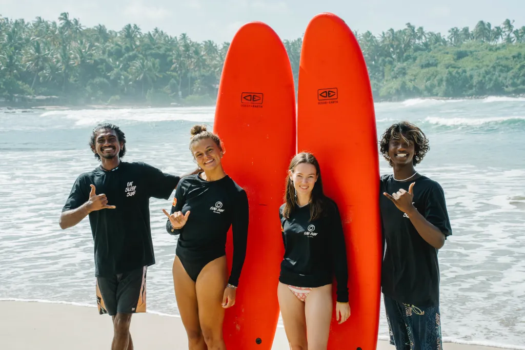 Happy kima surf guests with their surf guides on the beach in Hiriketiya